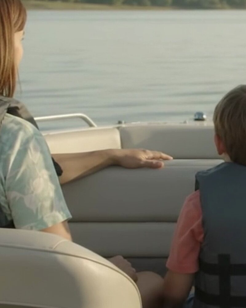 A family wearing life jackets aboard a recreational boat on a calm Texas lake
